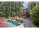 Backyard oasis features a stone pool and spa, outdoor kitchen and landscaped patio at 217 Fernwood Pl, Woodstock, GA 30188