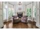 Relax in this peaceful sitting area with a beautiful fireplace and oversized windows at 217 Fernwood Pl, Woodstock, GA 30188