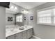 Bathroom with double sinks, gray cabinets, large mirror, and natural light at 3900 Baluster Ct, Suwanee, GA 30024