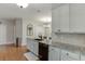 Well-lit kitchen featuring granite countertops, white cabinets, hardwood floors, and stainless steel appliances at 3900 Baluster Ct, Suwanee, GA 30024