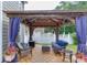 Relaxing patio with wood floors, ample seating, and a gazebo adorned with hanging curtains at 3900 Baluster Ct, Suwanee, GA 30024
