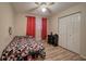 Bedroom with red patterned bedding, a ceiling fan, and a double door closet with laminate flooring at 4225 Parkridge Dr, Powder Springs, GA 30127