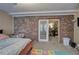 Bedroom showcasing carpet flooring, a brick wall, and a set of glass doors leading to the living area at 4225 Parkridge Dr, Powder Springs, GA 30127