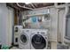 Functional laundry area equipped with modern washer, dryer, and storage shelving at 4225 Parkridge Dr, Powder Springs, GA 30127