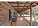 Relaxing covered porch with brick flooring and wood beam ceiling at 4225 Parkridge Dr, Powder Springs, GA 30127