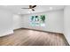 Bright bedroom with hardwood floors, white walls, three windows, and a modern ceiling fan at 597 Woodcrest Manor Dr, Stone Mountain, GA 30083