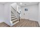 Bright entryway features hardwood floors, white walls, and a staircase with a wooden handrail leading to the upper level at 597 Woodcrest Manor Dr, Stone Mountain, GA 30083