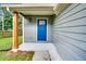Close-up of front door featuring a blue-painted door, a small porch, and decorative white stones at 597 Woodcrest Manor Dr, Stone Mountain, GA 30083