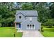 Charming two-story home featuring a blue exterior, a well-manicured lawn, and a paved driveway, set among lush green trees at 597 Woodcrest Manor Dr, Stone Mountain, GA 30083
