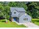 A charming two-story home showcases a blue exterior with a well-maintained yard, complemented by lush surrounding trees at 597 Woodcrest Manor Dr, Stone Mountain, GA 30083