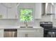 Well-lit kitchen featuring white cabinets, modern appliances, and a window view at 597 Woodcrest Manor Dr, Stone Mountain, GA 30083