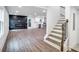 Bright, open-concept living space with hardwood floors, a fireplace, and a view of the kitchen and stairs at 597 Woodcrest Manor Dr, Stone Mountain, GA 30083