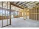 An unfinished basement has concrete floors, bare stud walls, exposed insulation, a back door, and several windows at 932 Melville Dr, Stockbridge, GA 30281