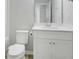A well-lit bathroom with a toilet, a mirror, and a vanity with storage space at 932 Melville Dr, Stockbridge, GA 30281