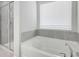 Bathroom featuring a separate glass shower and soaking tub with tile surround and window at 932 Melville Dr, Stockbridge, GA 30281