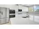 Modern kitchen featuring white cabinets, stainless steel appliances, and quartz countertops at 932 Melville Dr, Stockbridge, GA 30281
