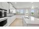 Well-lit kitchen with white cabinets, quartz countertops, stainless appliances, and island seating at 932 Melville Dr, Stockbridge, GA 30281