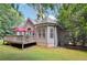 Home with a wooden deck, red umbrella, and well-maintained lawn surrounded by lush trees and greenery at 4472 Cavallon Nw Way, Acworth, GA 30101