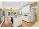 Open concept kitchen featuring white cabinets, a center island, modern appliances, and a view of the breakfast nook at 4472 Cavallon Nw Way, Acworth, GA 30101