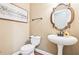 Elegant powder room featuring a pedestal sink, decorative mirror, and modern toilet at 4472 Cavallon Nw Way, Acworth, GA 30101