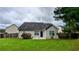 Back exterior showing vinyl siding, black door, lush lawn, and a wood fence at 4707 Golod Way, Lithonia, GA 30038