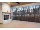Outdoor back porch with wooden floors, a brick fireplace, and a view of the trees at 125 Maison Court, Roswell, GA 30076