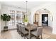 Elegant dining room featuring a large window, hardwood floors, and designer chandelier at 125 Maison Court, Roswell, GA 30076
