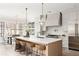 Modern kitchen with a large island, seating, a stainless steel refrigerator, and elegant pendant lights at 125 Maison Court, Roswell, GA 30076