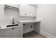 Well-lit laundry room with modern black sink, white countertops, and storage cabinets at 125 Maison Court, Roswell, GA 30076