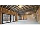 Unfinished living room space with exposed wooden framework, concrete floor, and large sliding doors to the backyard at 125 Maison Court, Roswell, GA 30076