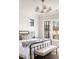 Bright main bedroom offers paneled walls and black frame windows showcasing natural views at 125 Maison Court, Roswell, GA 30076