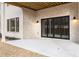 Back patio with concrete floors, brick walls and dark framed sliding doors overlooking the wooded yard at 125 Maison Court, Roswell, GA 30076