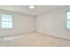 This bedroom features two windows for lots of light, neutral carpet, and white paint at 1338 Talcott Pl, Decatur, GA 30033