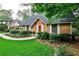 A cozy single-story brick house with a manicured lawn, mature trees, and a welcoming red front door at 1338 Talcott Pl, Decatur, GA 30033