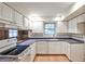 Bright kitchen with white cabinets, dark countertops, modern appliances, and hardwood floors at 1338 Talcott Pl, Decatur, GA 30033