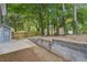 View of a fenced backyard with trees and a concrete patio at 2079 Wellborn Rd, Lithonia, GA 30058