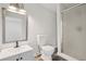 Bathroom featuring new gray vanity, gray mirror, toilet, and glass enclosed shower at 2079 Wellborn Rd, Lithonia, GA 30058