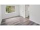 Bright bedroom with wood-look flooring, a double closet, and a window providing ample natural light at 2079 Wellborn Rd, Lithonia, GA 30058