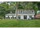 Charming two-story home featuring a manicured lawn, gray siding and a striking black front door at 2079 Wellborn Rd, Lithonia, GA 30058