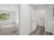 This hallway features wood-look flooring and leads to a bedroom, with an adjacent door to the laundry room at 2079 Wellborn Rd, Lithonia, GA 30058
