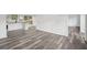 Open concept living space with modern flooring flows into a kitchen with bright white cabinetry at 2079 Wellborn Rd, Lithonia, GA 30058