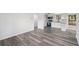 Open concept living space with modern flooring flows into a bright white kitchen with modern appliances at 2079 Wellborn Rd, Lithonia, GA 30058