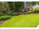 Well-manicured front lawn with mature trees and shrubbery, creating a park-like setting at 3300 Pierce St, College Park, GA 30337
