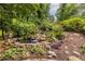 Beautiful koi pond with a small waterfall feature surrounded by lush greenery and rock border at 3300 Pierce St, College Park, GA 30337