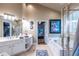 Bright bathroom with white vanity, tiled floors, soaking tub, and glass-enclosed shower at 3300 Pierce St, College Park, GA 30337