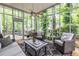 Cozy sunroom with wicker furniture and serene views of the lush, wooded backyard at 3300 Pierce St, College Park, GA 30337