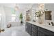 Bright bathroom with double vanity, soaking tub, stylish light fixture and marble floors at 4340 Hadaway Nw Rd, Kennesaw, GA 30152