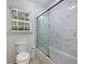 This is a bathroom with a sliding glass shower door, subway tiles, and a toilet near the window at 1355 E Rock Springs Ne Rd, Atlanta, GA 30306