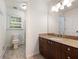 Bathroom featuring granite counters, wood cabinets, tile flooring, and a bright window at 1355 E Rock Springs Ne Rd, Atlanta, GA 30306