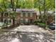 Charming brick townhome featuring a driveway and surrounded by mature trees at 1355 E Rock Springs Ne Rd, Atlanta, GA 30306